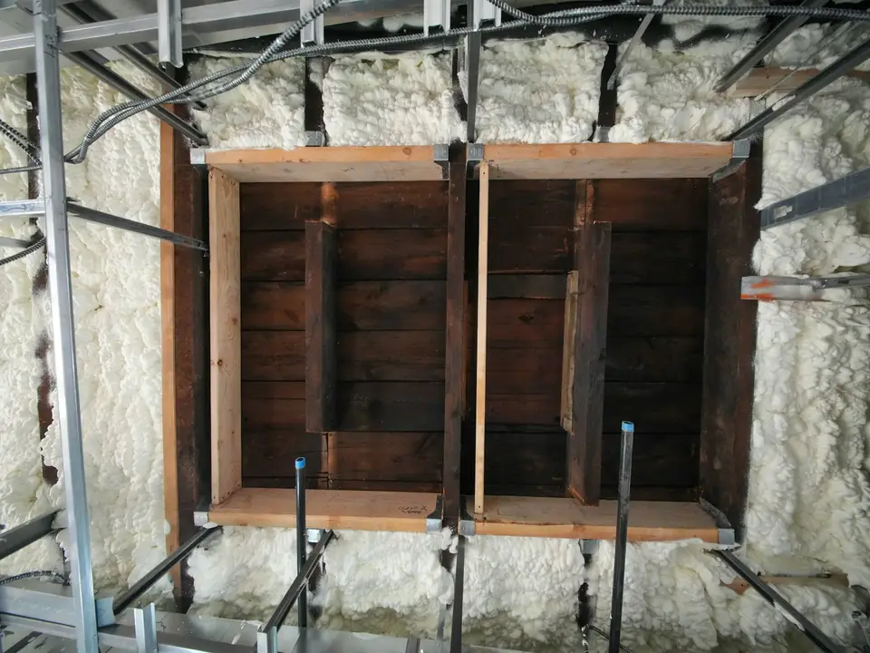 Wall framing with spray foam insulation between the studs
